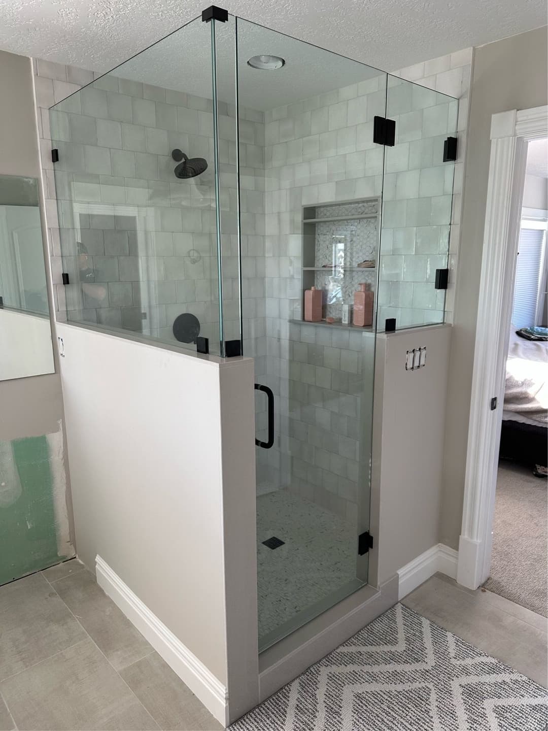 Modern glass shower enclosure with tiled walls and sleek fixtures in a stylish bathroom.